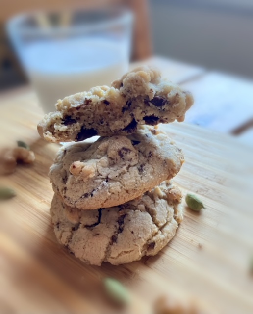 Brown butter chocolate chunk cookies with cardamom stacked on cutting board