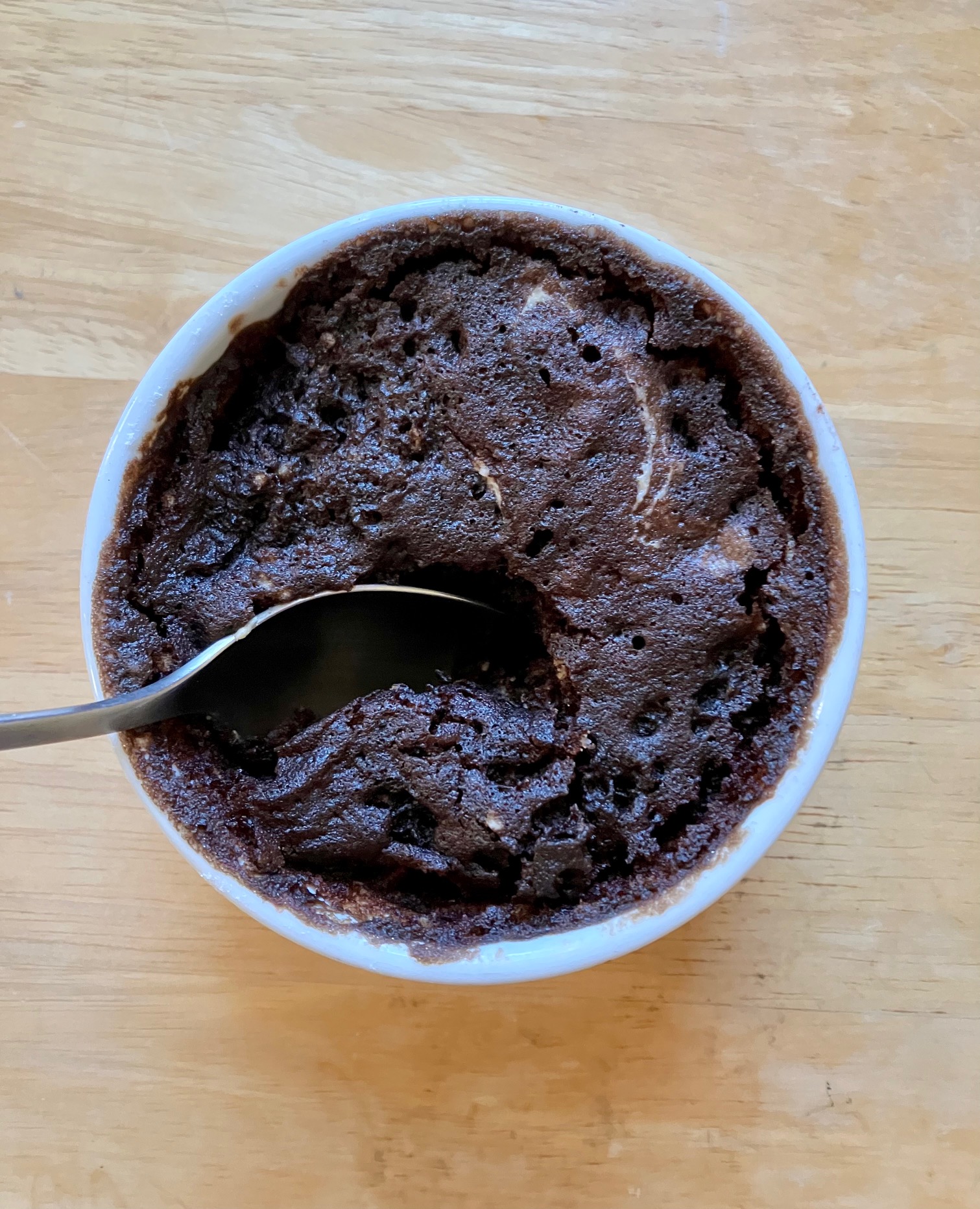 emergency chocolate mug cake in a ramekin with a spoon