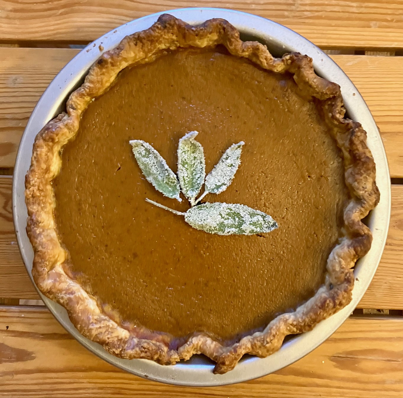 brown butter pumpkin pie with candied sage on top