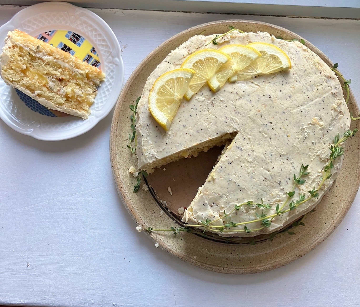 lemon thyme cake with a piece cut out an placed on a plate